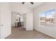 A well-lit room featuring wood-look tile floors, a ceiling fan, and a view to the dining area at 1410 S Boulder St # A, Gilbert, AZ 85296