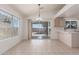 Dining area filled with natural light, tile floors, neutral colors, a bar counter and access to the backyard at 14561 W Winding Trl, Surprise, AZ 85374