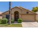 Charming single-story home featuring a well-maintained yard, arched entryway, and a two-car garage at 14561 W Winding Trl, Surprise, AZ 85374