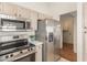 Bright kitchen with stainless steel appliances, quartz countertops, and wood cabinets at 14561 W Winding Trl, Surprise, AZ 85374