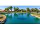 Aerial view of a pond surrounded by green lawns, houses and landscaping at 14561 W Winding Trl, Surprise, AZ 85374