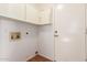 A functional utility room includes overhead cabinets, convenient water hookups, and durable flooring at 14561 W Winding Trl, Surprise, AZ 85374