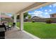 Covered patio with view of lush backyard and privacy fence at 14922 N 172Nd Dr, Surprise, AZ 85388