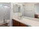 Well-lit bathroom with a marble countertop, modern sink, and glass-enclosed shower at 14922 N 172Nd Dr, Surprise, AZ 85388