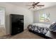 Cozy bedroom with carpet, black wardrobe, and a bright window view at 14922 N 172Nd Dr, Surprise, AZ 85388