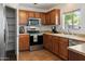 Functional kitchen with wooden cabinets, stainless steel appliances, and a view of the backyard at 14922 N 172Nd Dr, Surprise, AZ 85388