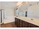 Bright bathroom featuring a tub, glass-enclosed shower, and double vanity at 1710 S Parkcrest St, Gilbert, AZ 85295