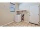 Functional laundry room with tile floors, washer hookups, a storage shelf, and exterior access at 1710 S Parkcrest St, Gilbert, AZ 85295
