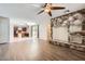 Open-concept living room featuring wood floors, stone fireplace, and seamless flow to the kitchen and backyard at 1710 S Parkcrest St, Gilbert, AZ 85295