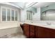 Bathroom features dual sinks, tub, plantation shutters, and a large mirror at 17853 W Pershing St, Surprise, AZ 85388