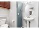 Powder room featuring pedestal sink, toilet, overhead cabinet, and decorative mirror at 17853 W Pershing St, Surprise, AZ 85388