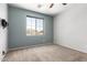 Bedroom with carpeted floors, two-tone walls, and a window overlooking a neighborhood at 17853 W Pershing St, Surprise, AZ 85388