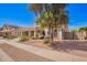 Charming front yard with drought-tolerant landscaping, mature trees, and a well-maintained lawn at 17853 W Pershing St, Surprise, AZ 85388