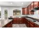 Kitchen with stainless appliances, dark cabinets, granite counters and views of the backyard pool at 17853 W Pershing St, Surprise, AZ 85388