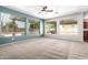 Bright living room with carpet, ceiling fan, and large windows overlooking backyard at 17853 W Pershing St, Surprise, AZ 85388