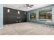 Spacious living room featuring plush carpet, large windows, and a ceiling fan at 17853 W Pershing St, Surprise, AZ 85388