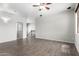 Spacious living room with laminate flooring, a ceiling fan, and hallway access at 17853 W Pershing St, Surprise, AZ 85388