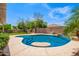 Sparkling pool with an in-pool table, surrounding patio and lush landscaping at 17853 W Pershing St, Surprise, AZ 85388