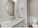Elegant powder room with white vanity, round mirror, and modern fixtures at 1854 W Fetlock Trl, Phoenix, AZ 85085