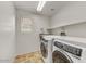 Laundry room features a front load washer and dryer, shelf and a window at 1854 W Fetlock Trl, Phoenix, AZ 85085