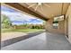Covered patio with ceiling fan and mounted TV overlooking the landscaped backyard at 1854 W Fetlock Trl, Phoenix, AZ 85085