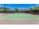 Well-maintained tennis court with a net, surrounded by lush greenery and offering a great recreational activity at 1854 W Fetlock Trl, Phoenix, AZ 85085