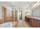This bathroom features a soaking tub, shower with glass door, double vanity, and tile floors at 20082 N 272Nd Ln, Buckeye, AZ 85396