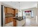 The kitchen has granite counters, an island with a sink, wooden cabinets, and stainless steel appliances at 20082 N 272Nd Ln, Buckeye, AZ 85396