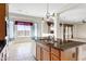 The kitchen has granite counters, an island with a sink, wooden cabinets, and stainless steel appliances at 20082 N 272Nd Ln, Buckeye, AZ 85396