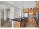 The kitchen has granite counters, an island with a sink, wooden cabinets, and stainless steel appliances at 20082 N 272Nd Ln, Buckeye, AZ 85396