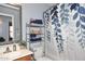 Well-lit bathroom with decorative shower curtain and organized shelving unit at 2727 S 160 Ln, Goodyear, AZ 85338