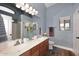 Bathroom featuring double sinks, wood cabinets, and a window at 2727 S 160 Ln, Goodyear, AZ 85338