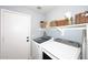 Bright laundry room with modern washer and dryer and storage shelves at 2727 S 160 Ln, Goodyear, AZ 85338