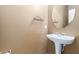 Cozy powder room featuring a pedestal sink, decorative accents, and warm neutral tones, ideal for guests at 2854 N Claire Dr, Buckeye, AZ 85396