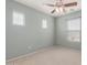 Bedroom with carpet, three windows, and a ceiling fan at 2854 N Claire Dr, Buckeye, AZ 85396