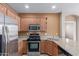 Modern kitchen boasts stainless steel appliances, stone counter tops, and light wood cabinets at 2854 N Claire Dr, Buckeye, AZ 85396