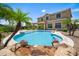 Gorgeous backyard pool with tropical palms, rock features, and luxurious outdoor living at 31221 N 130Th Ln, Peoria, AZ 85383