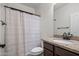Cozy bathroom featuring a granite countertop, vanity, shower with curtain and modern fixtures at 31221 N 130Th Ln, Peoria, AZ 85383