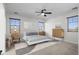 Staged bedroom features neutral colors, ceiling fan, and window views at 31221 N 130Th Ln, Peoria, AZ 85383