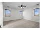 Neutral carpeted bedroom features three windows and a ceiling fan at 31221 N 130Th Ln, Peoria, AZ 85383