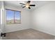 Neutral carpeted bedroom features a view of the local mountain and a ceiling fan at 31221 N 130Th Ln, Peoria, AZ 85383