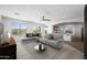 Bright living room with a comfortable gray sofa, ceiling fan and a view of the backyard pool at 31221 N 130Th Ln, Peoria, AZ 85383