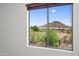 A window view from the home overlooks desert landscaping and a mountain at 31221 N 130Th Ln, Peoria, AZ 85383