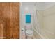 Bathroom with toilet and a shower/tub combo and wood door at 4065 E University -- # 433, Mesa, AZ 85202