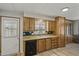 Cozy kitchen with wood cabinets, black dishwasher, bright lighting, and convenient exterior door at 4065 E University -- # 433, Mesa, AZ 85202