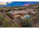 An aerial view showcases the beautiful home, pool, and mountain views at 42101 N Olympic Fields Ct, Anthem, AZ 85086