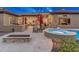 A sprawling backyard offers a relaxing spa, an inviting pool, a built-in BBQ, and a cozy fire pit at 42101 N Olympic Fields Ct, Anthem, AZ 85086