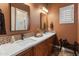 Bathroom featuring dual sinks, stylish tile backsplash, vanity lighting and modern mirrors at 42101 N Olympic Fields Ct, Anthem, AZ 85086