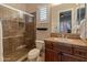 Bathroom with earth-toned tile shower, marble countertop, and wood vanity at 42101 N Olympic Fields Ct, Anthem, AZ 85086