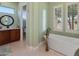 Bathtub with bronze fixtures and windows for natural light at 42101 N Olympic Fields Ct, Anthem, AZ 85086
